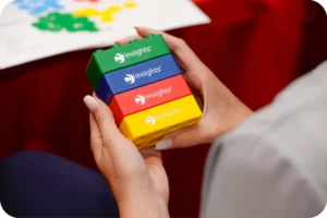 Close up of a man holding green, blue, red and yellow Insight blocks